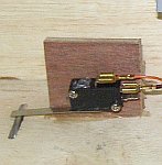 Long arm micro switch behind the coin mechanism