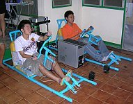 Thai students playing Daytona USA in PVC racing cars