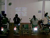 Playing GL-Tron indoors with four players using real motorbikes