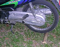 Motorbike with the center stand down and a half section of bamboo jammed beneath the rear wheel